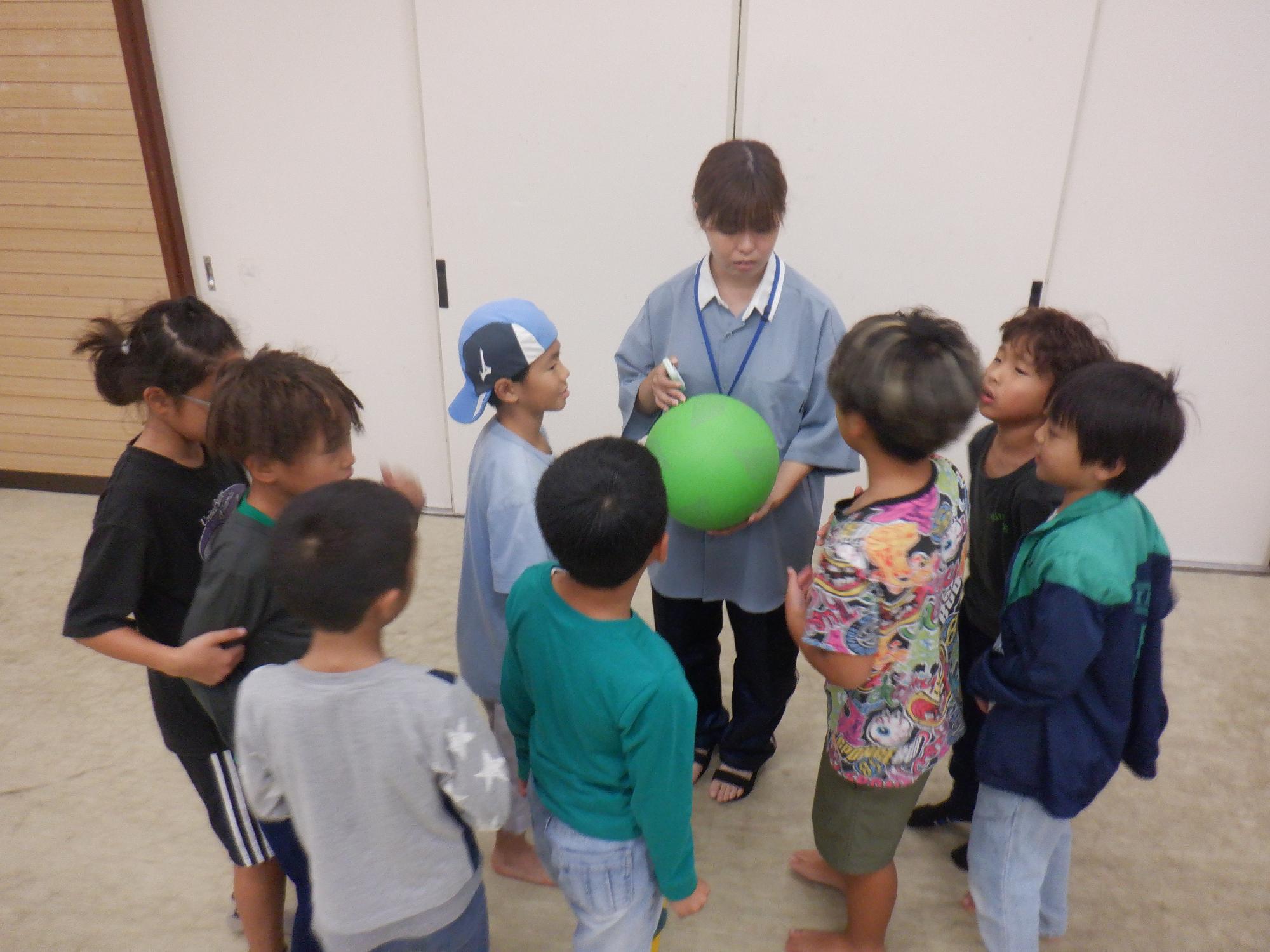 小学生低学年児童がドッジボールのルールを確認している様子の写真