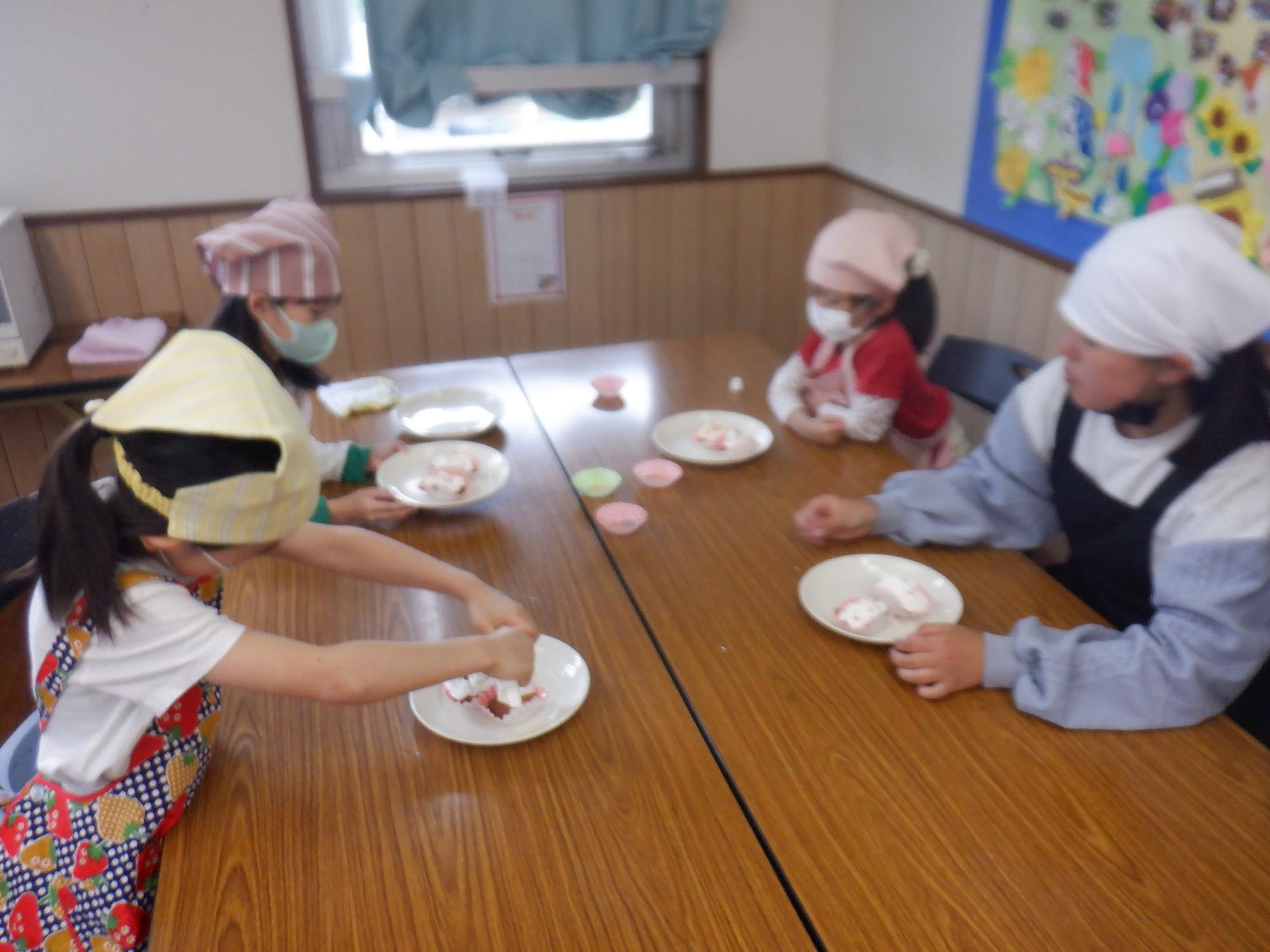 焼きあがったカップケーキにトッピングをしている様子の写真
