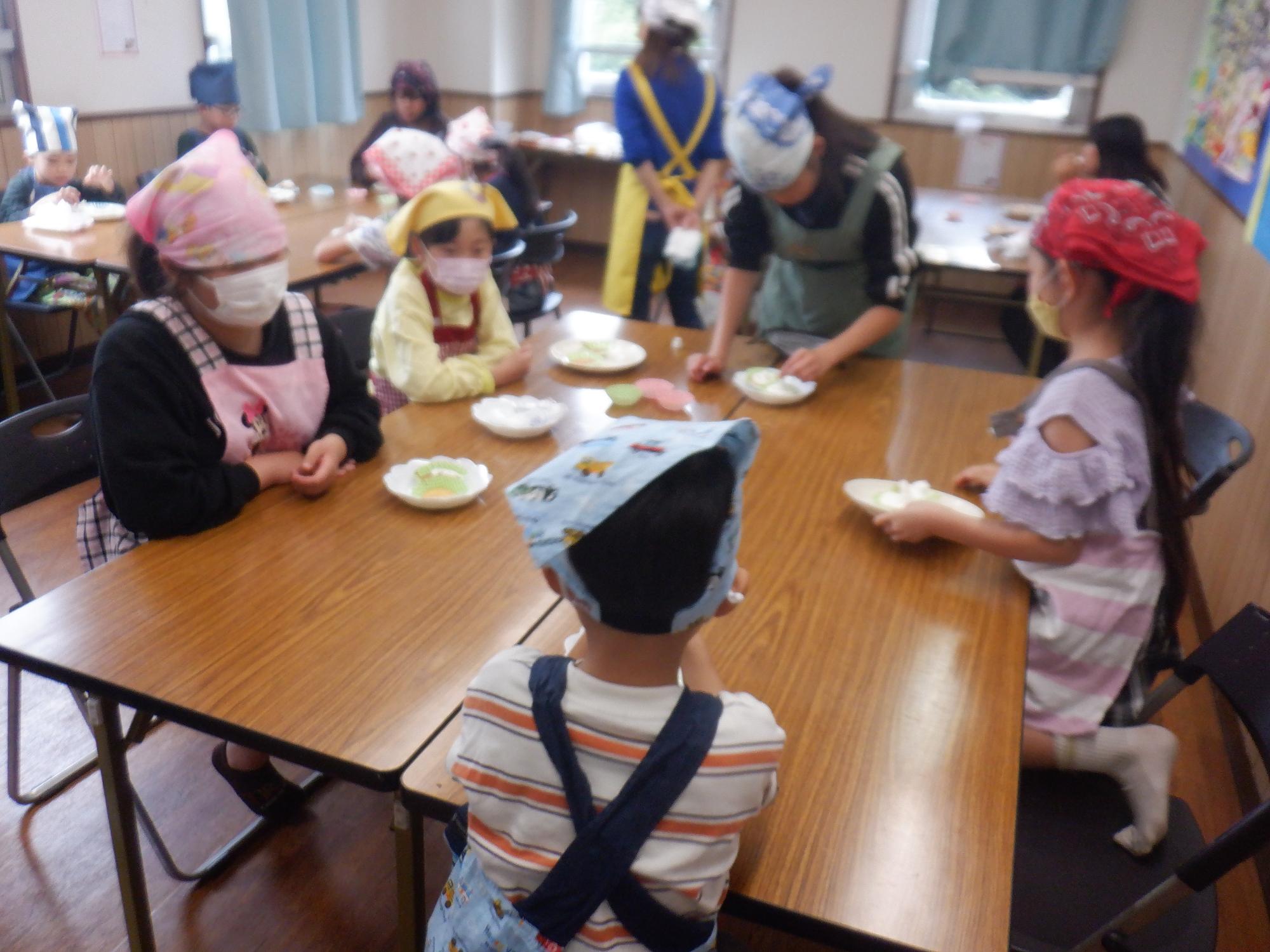 焼きあがったカップケーキにトッピングをする様子の写真