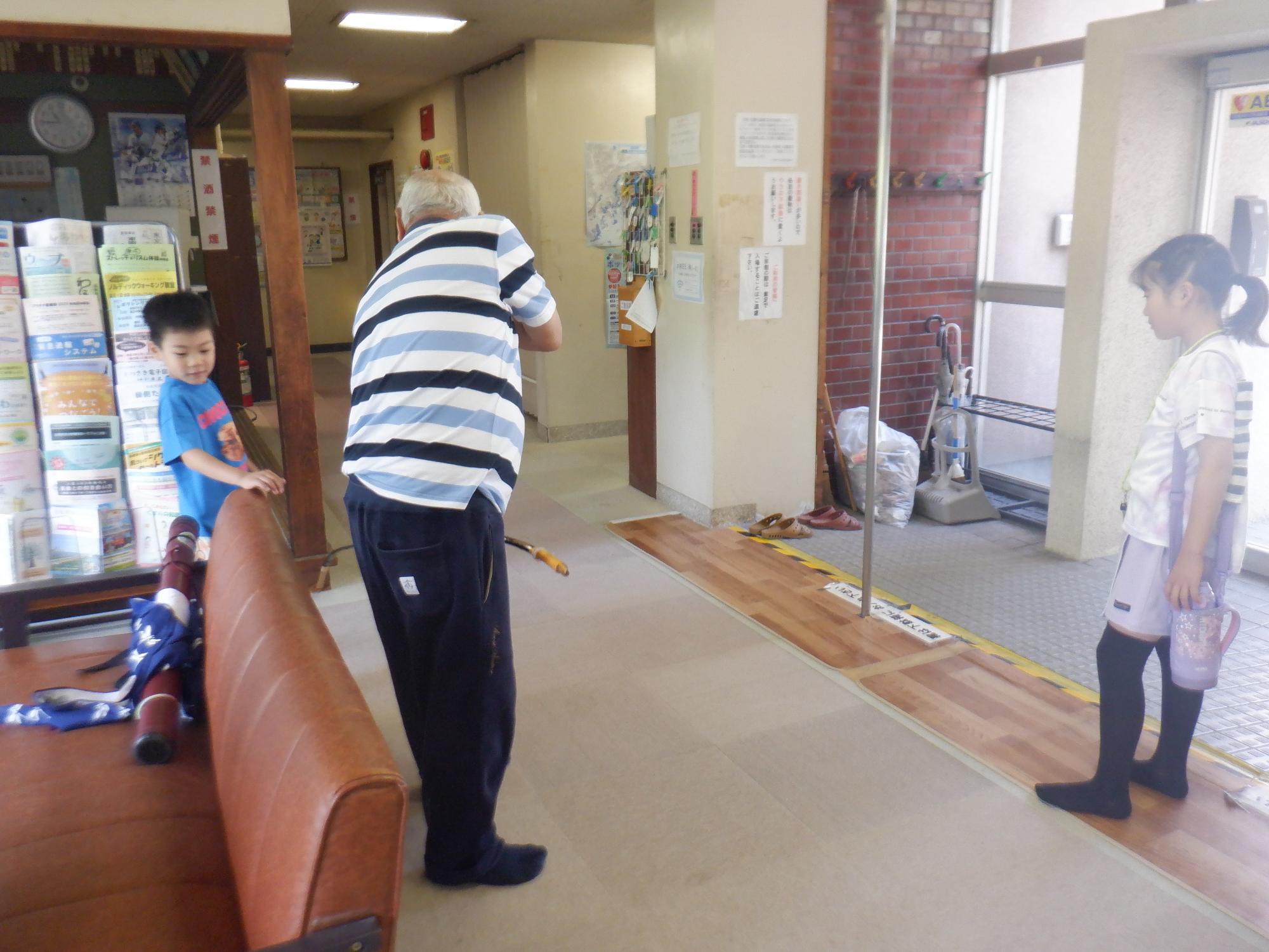 弓をみせてくれたいこいの家の利用者と子どもたち