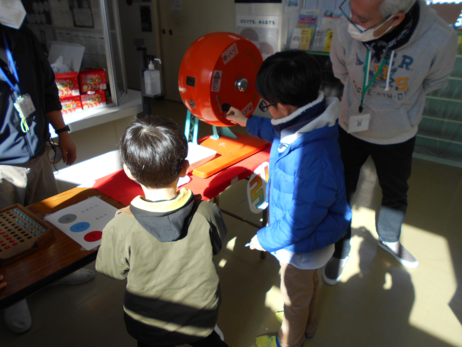 福引きに挑戦する兄弟の写真