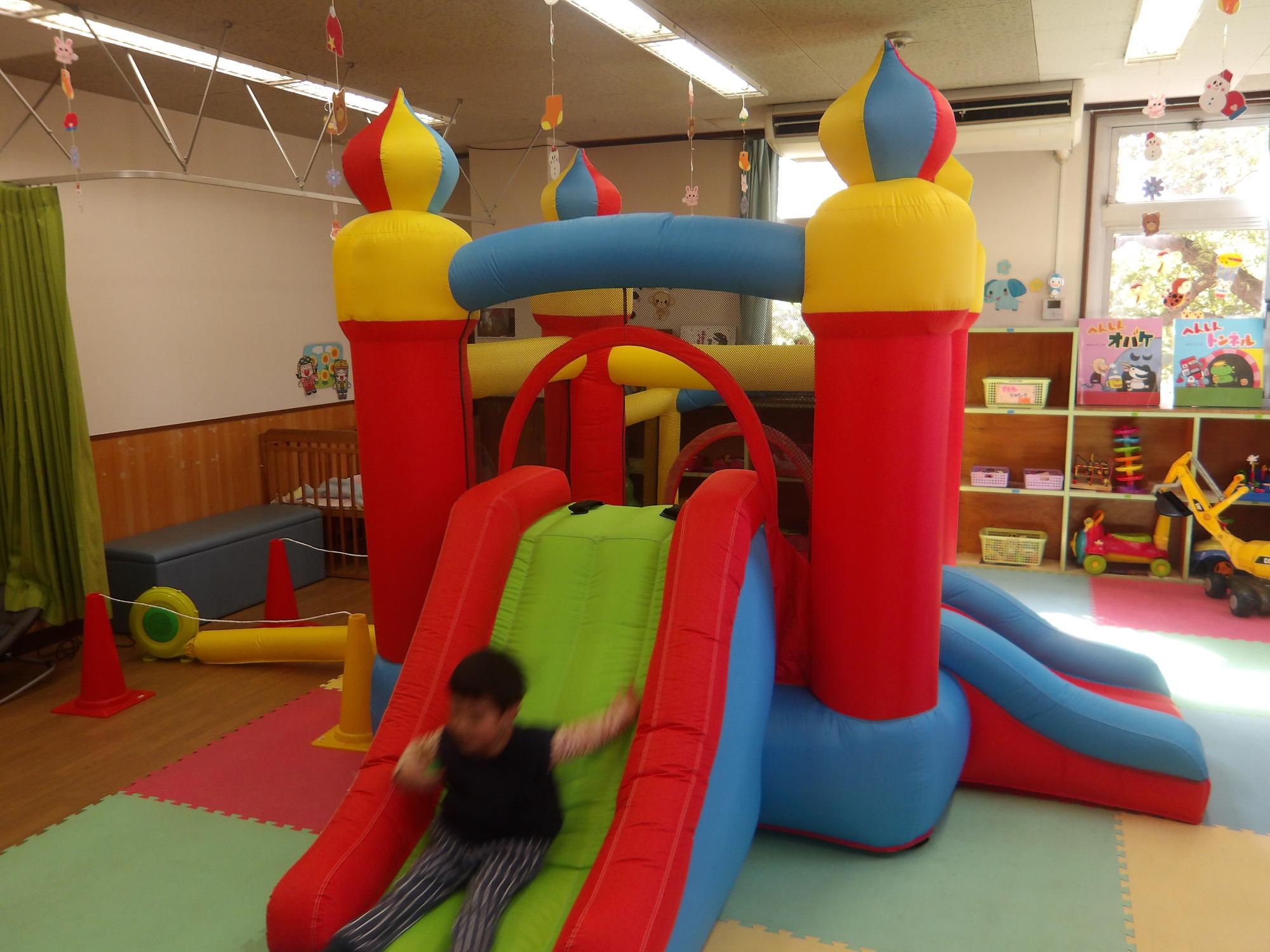 大型遊具のすべり台で遊ぶ幼児の写真