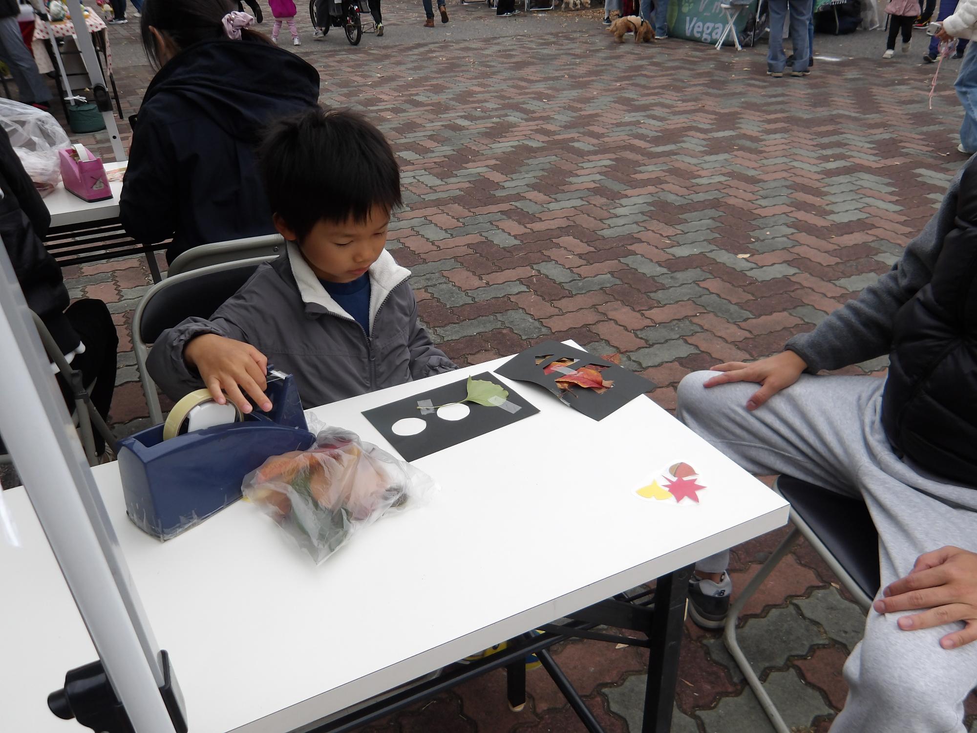 落ち葉でステンドグラフをしている子ども