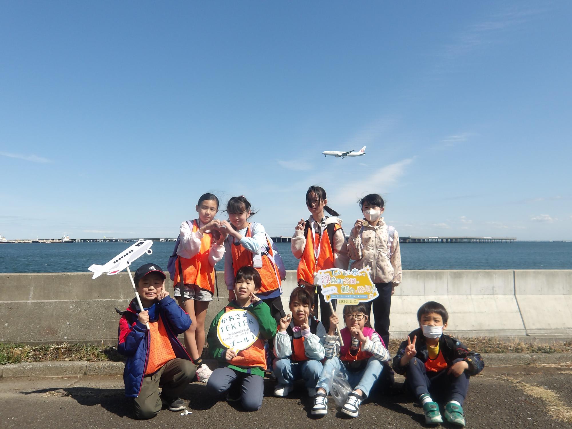 着陸する飛行機をバックに撮った集合写真