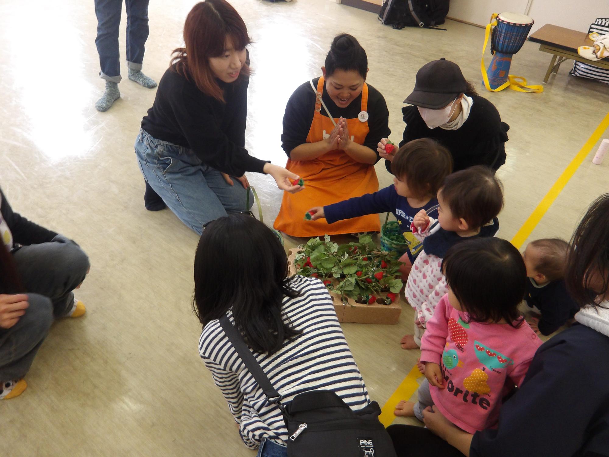 いちごの模型を使って、いちご狩りを体験する幼児の様子