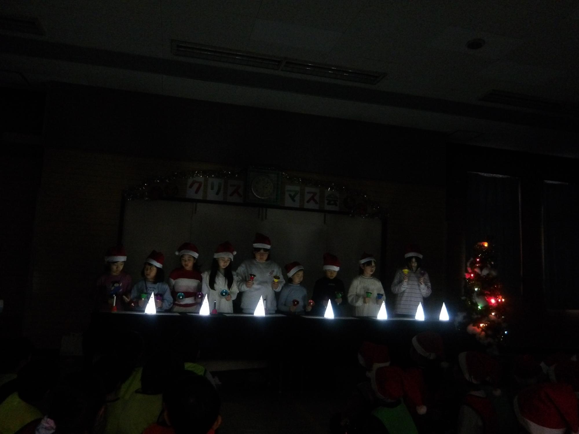 クリスマス会でハンドベルクラブが「サンタが街にやってくる」を演奏している様子