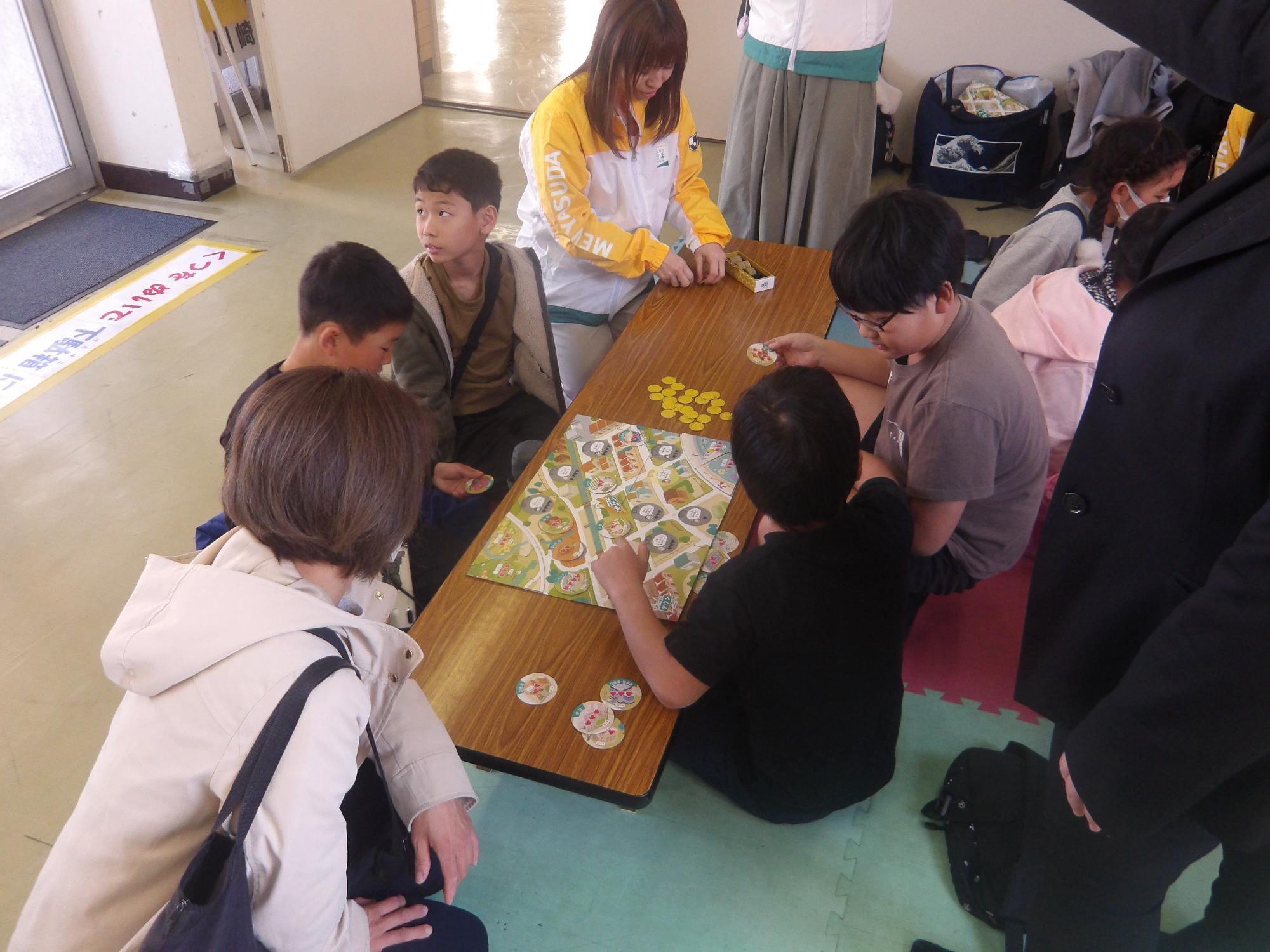 明治安田の方とボードゲームをする小学生の様子