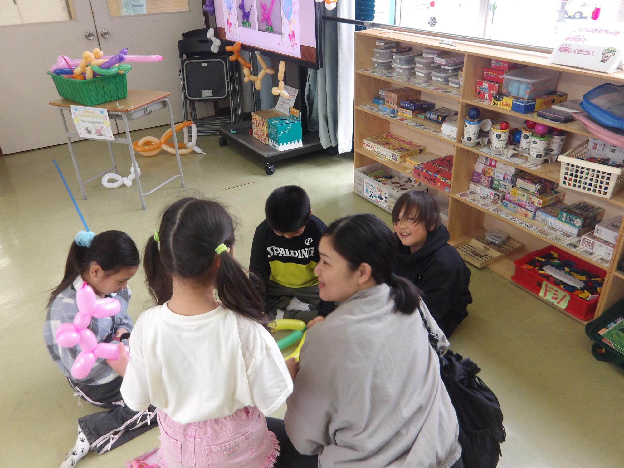 小学生からバルーンをもらう幼児親子の様子