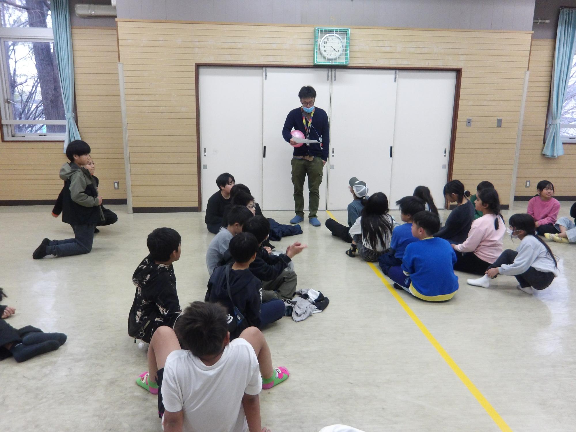 ドッジボールタイムに参加する小学生が集まって、説明を受けている様子