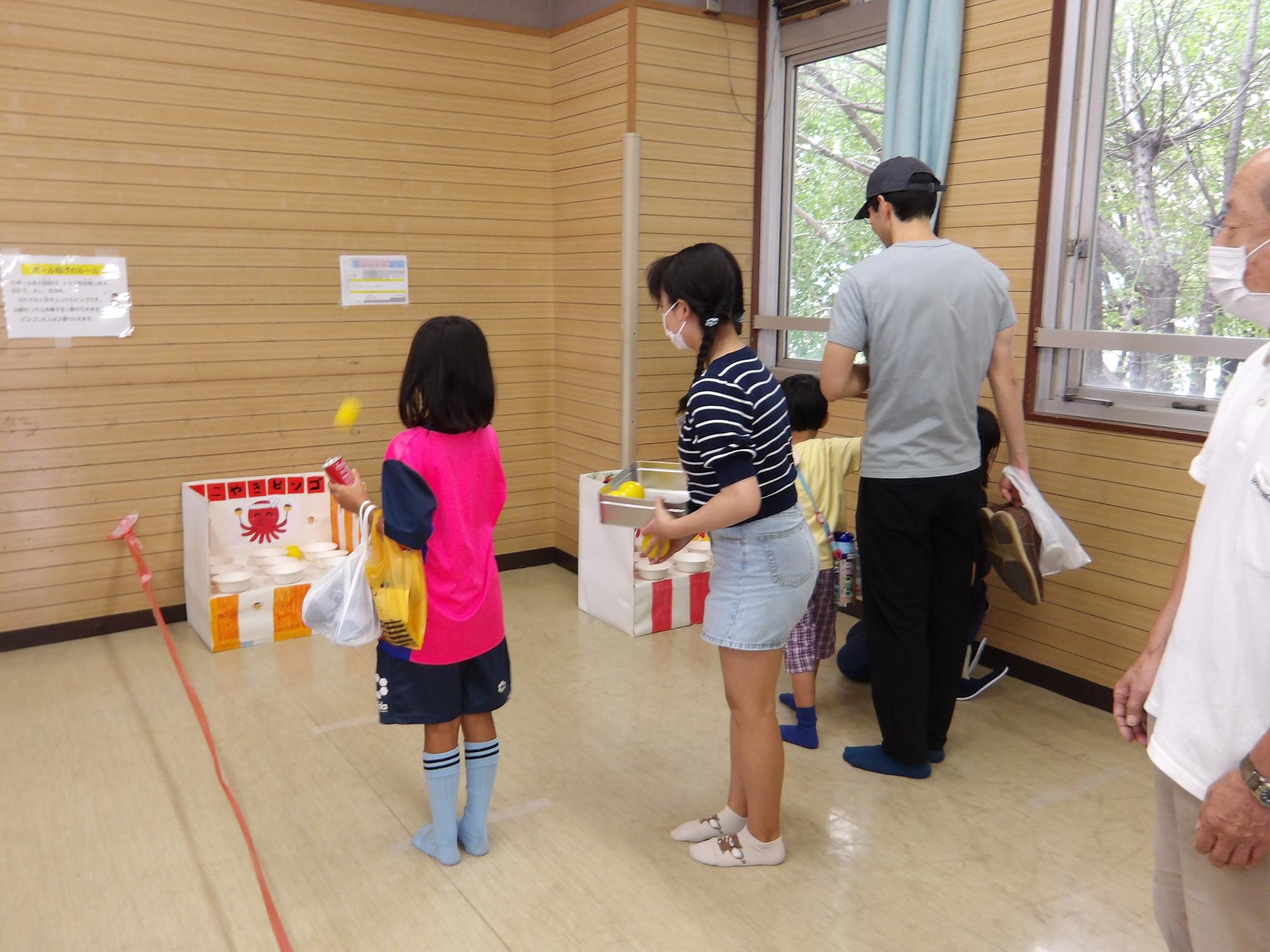 集会室で行われたボール投げに挑戦する参加者の写真