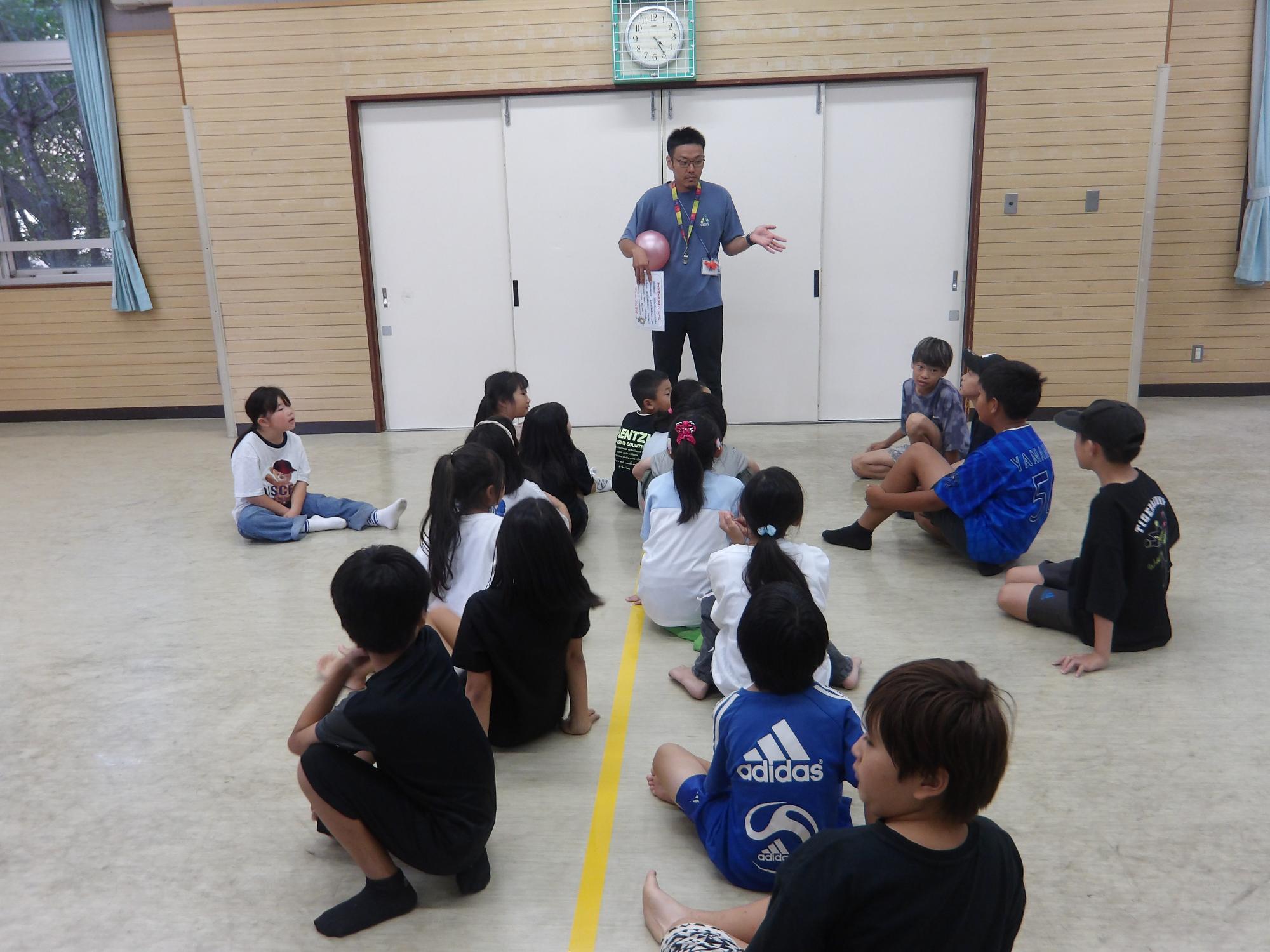 集会室でドッジボールルールを確認している様子の写真