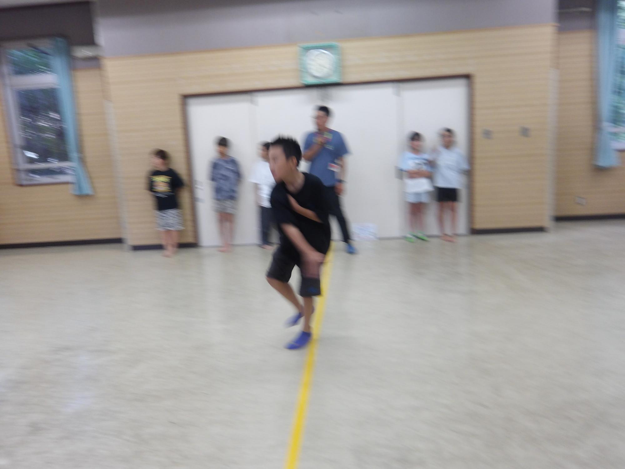 集会室でドッジボールを楽しむ小学生児童の写真