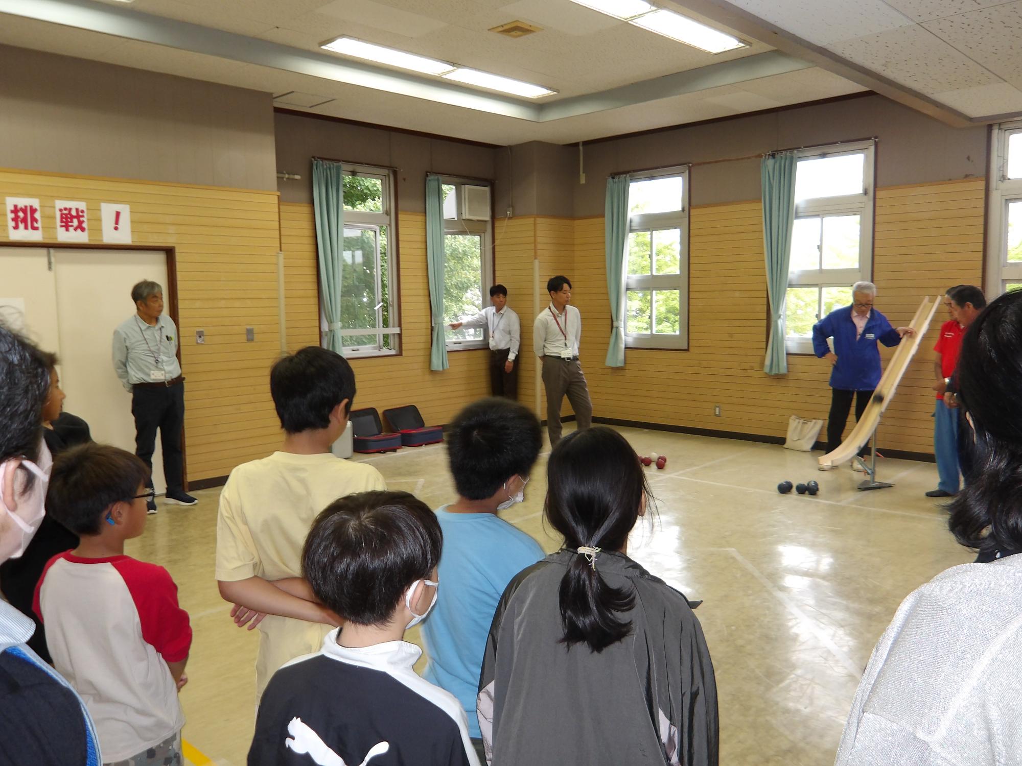 ボッチャに使われる道具、器具についての説明を聞いている様子