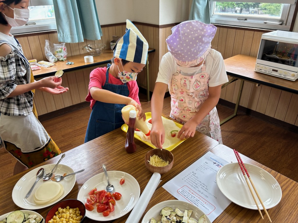 だいしファームメンバーが育てた野菜を盛付けている写真