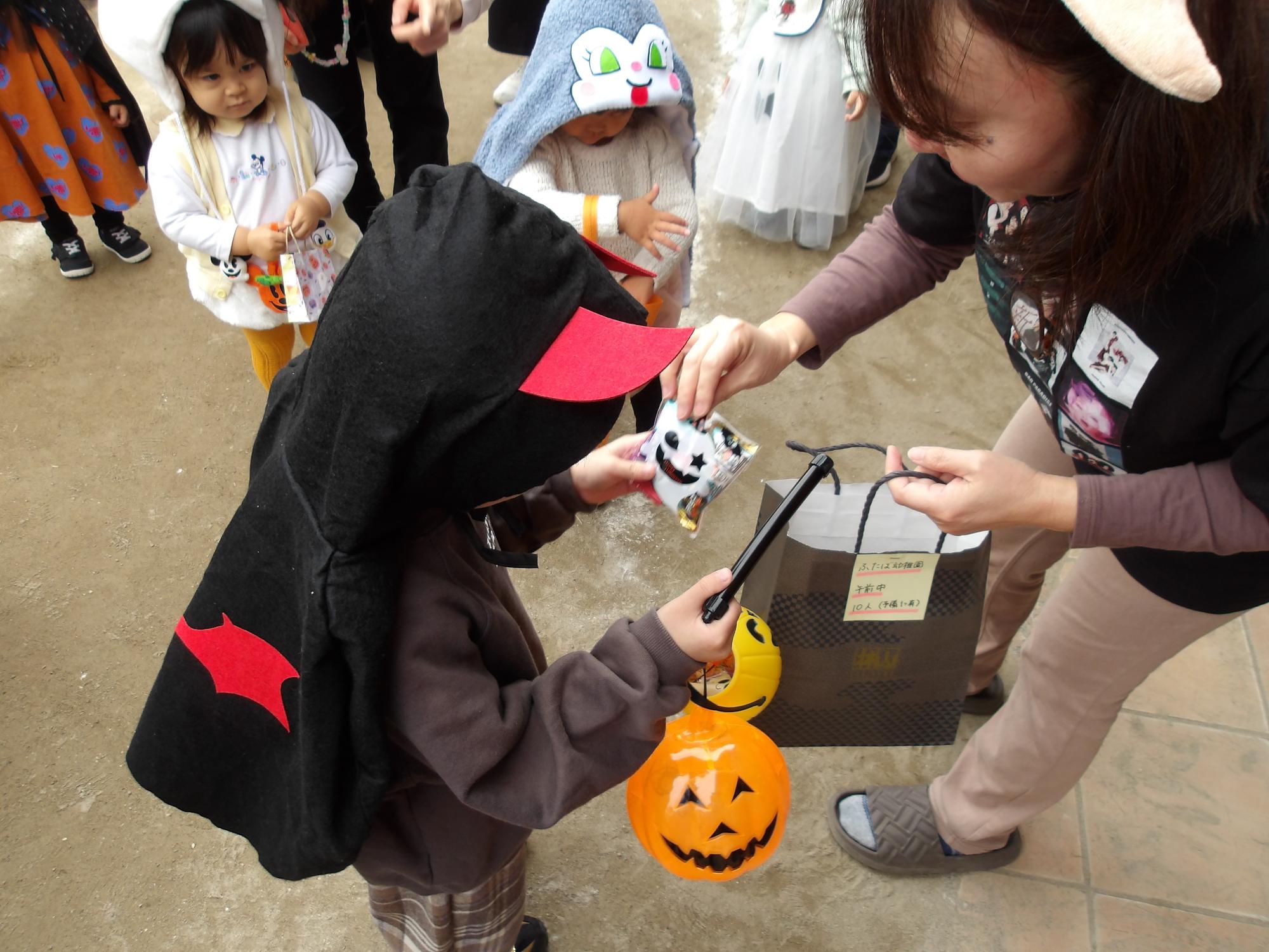 トリックオアトリートの掛け声とともにお菓子をもらう様子