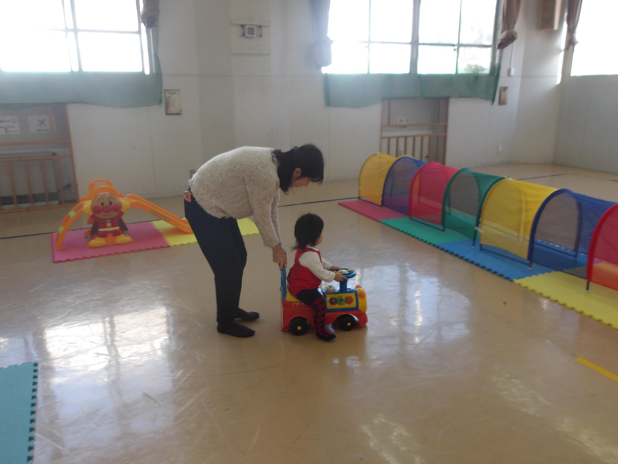 車のおもちゃにまたいで遊んでいる様子