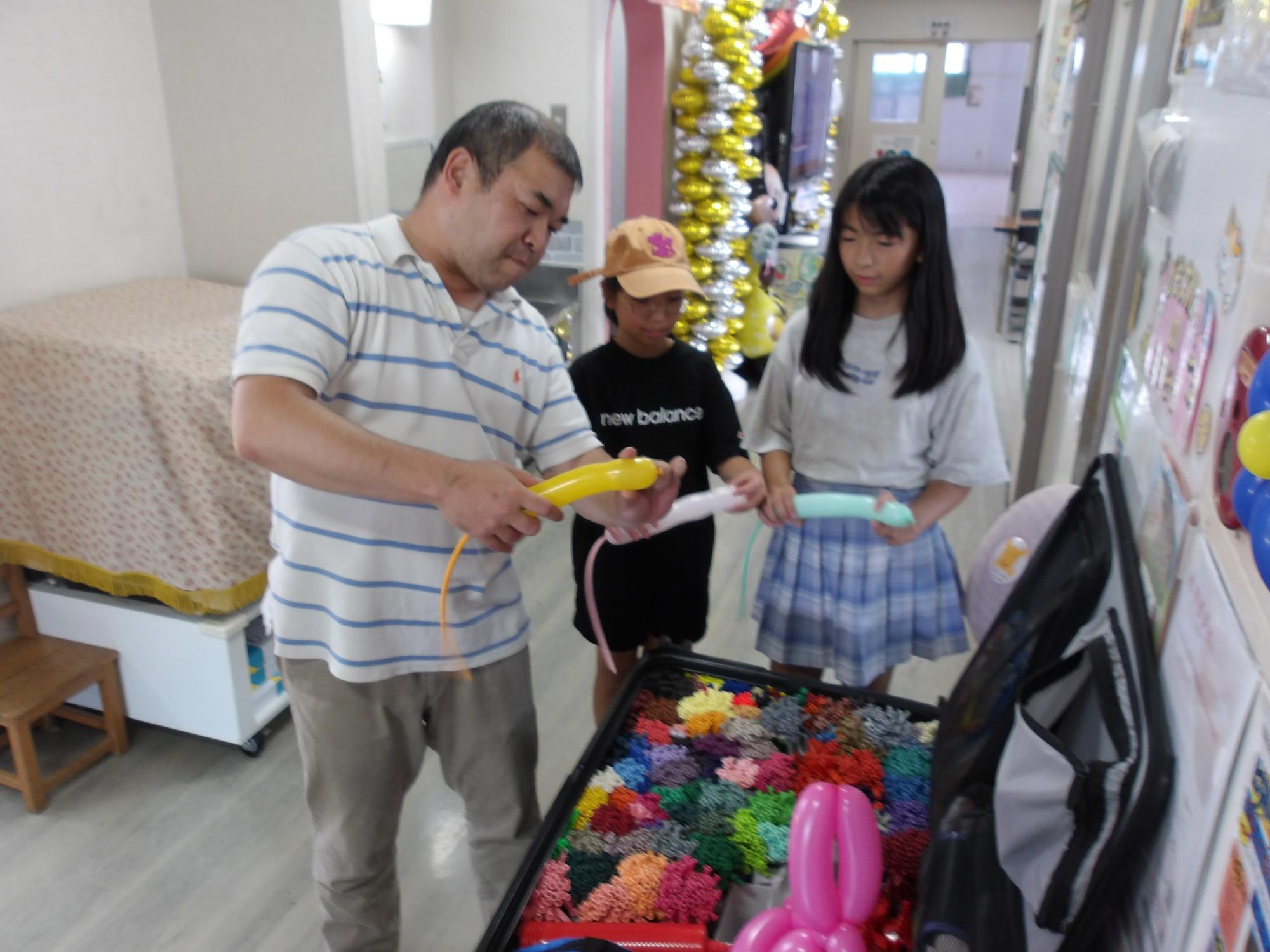 ねずみの風船の作り方を教わっている様子