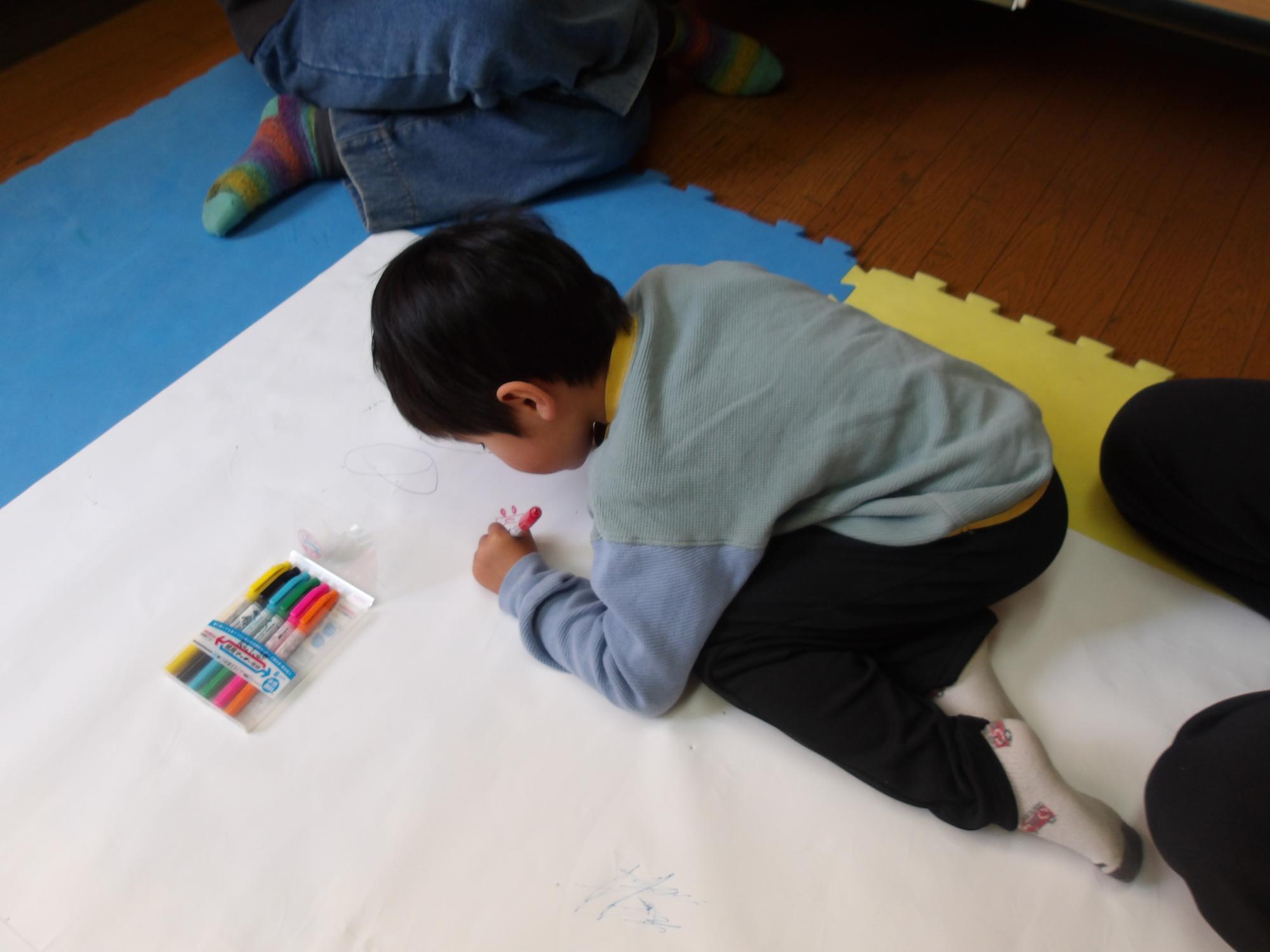 こどもがイラストを描いているところ