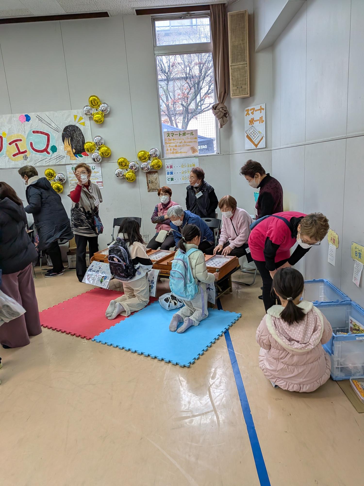 スマートボールを楽しんでいる子と景品を選んでいる子の写真