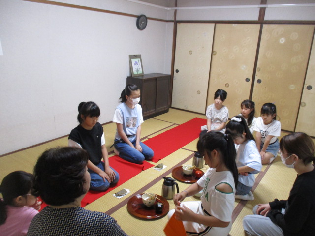 クラブ員の子どもたちが茶道の作法を見て学んでいる様子の写真