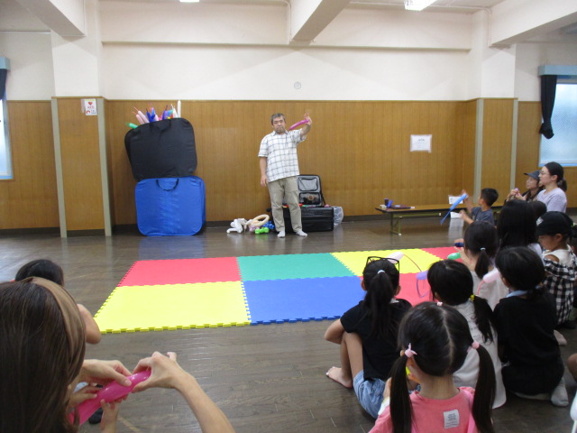 バルーンアートの作り方を教える講師と参加者の様子の写真