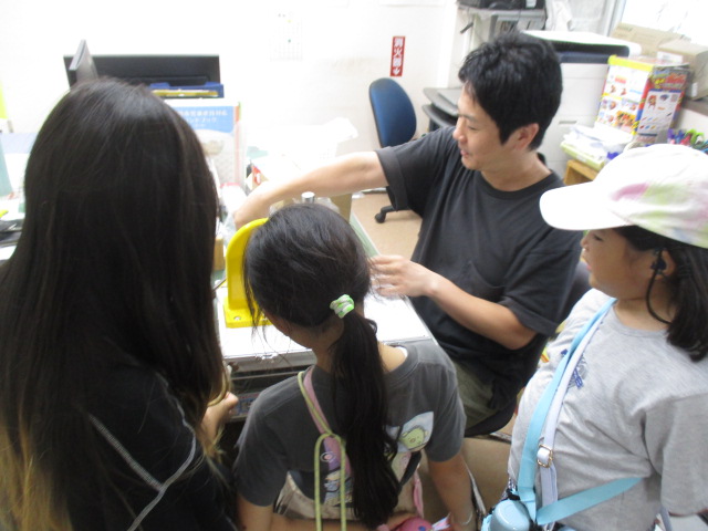 缶バッチを作っている子どもと職員の様子の写真