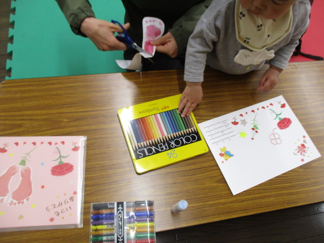 測定会で4月の測定カードを作成している乳幼児親子の様子の写真