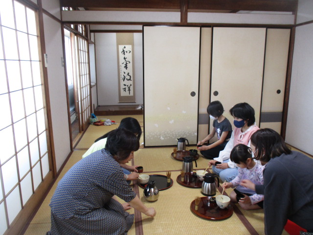 茶道体験会の講師がお茶の点て方を実践している様子の写真