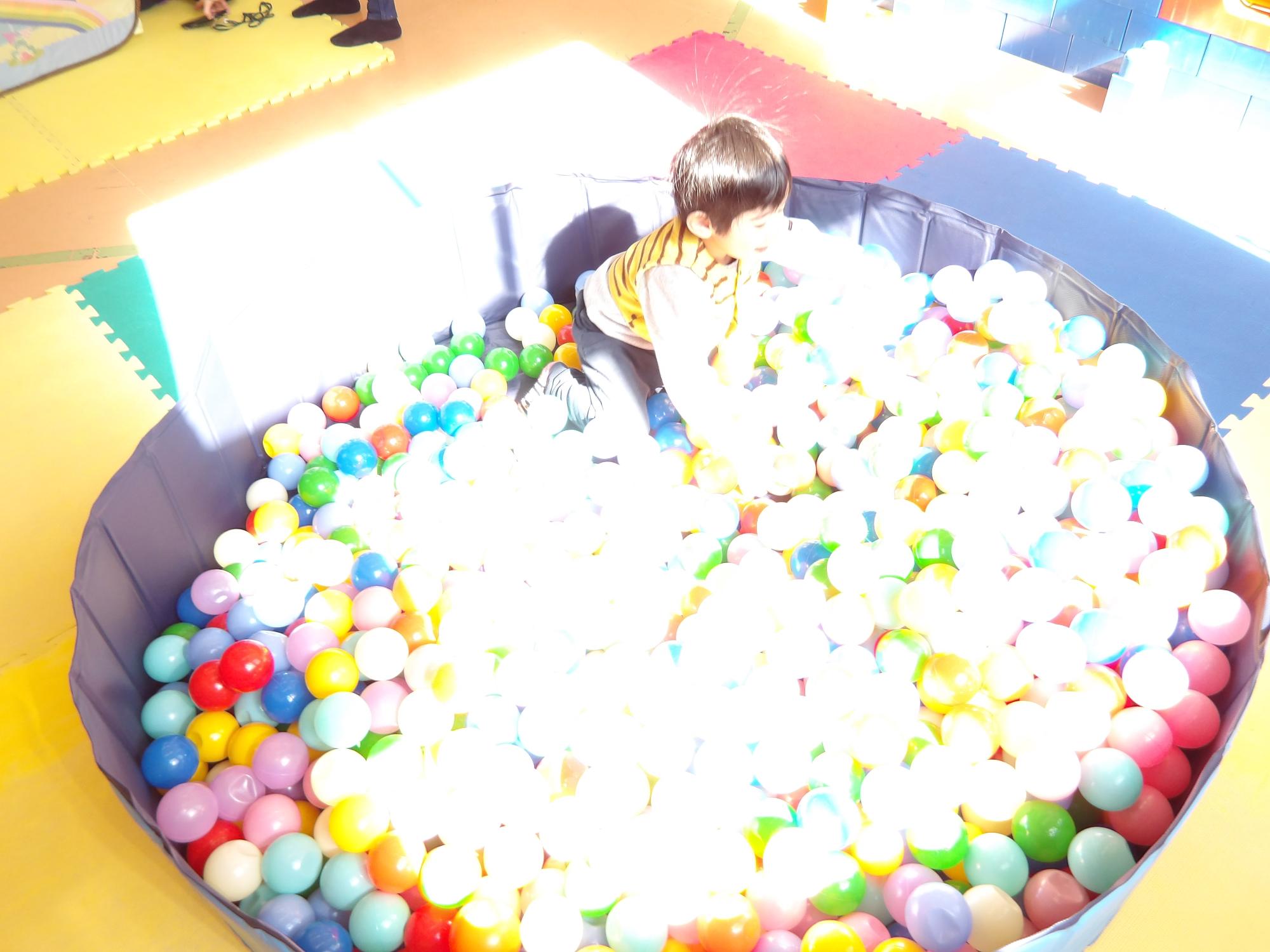 幼児がボールプールで遊んでいる写真