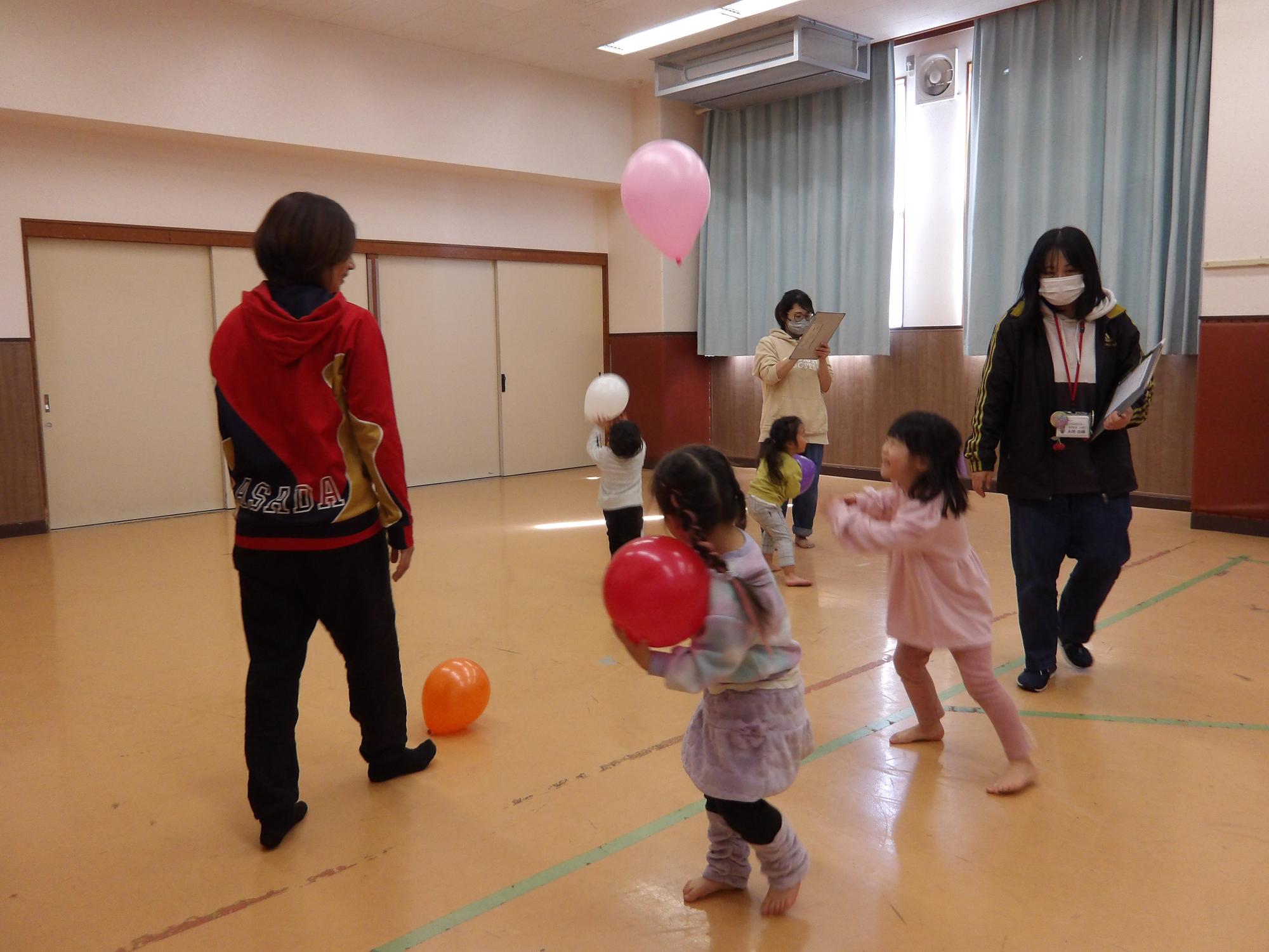 幼児たちが風船で遊んでいる写真