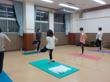 曲げた左足を右の内腿に付けるポーズをしている4人の参加者と講師の写真
