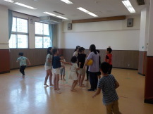 施設内で先生の周りに集まる大勢の子供たちの写真