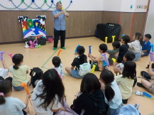 講師の先生の真似をしてバルーン体験をしている子供たちの写真