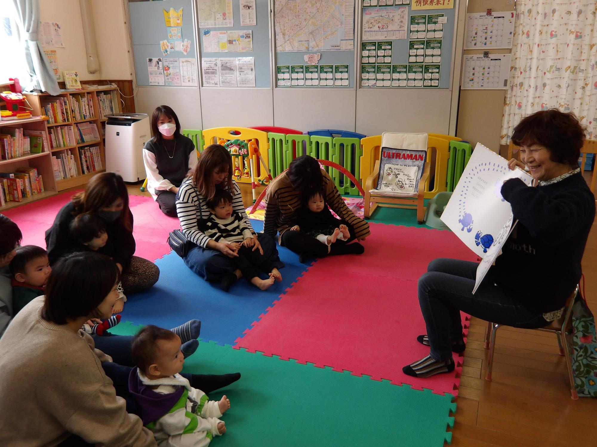 巨大な絵本の読み聞かせをしている様子の写真