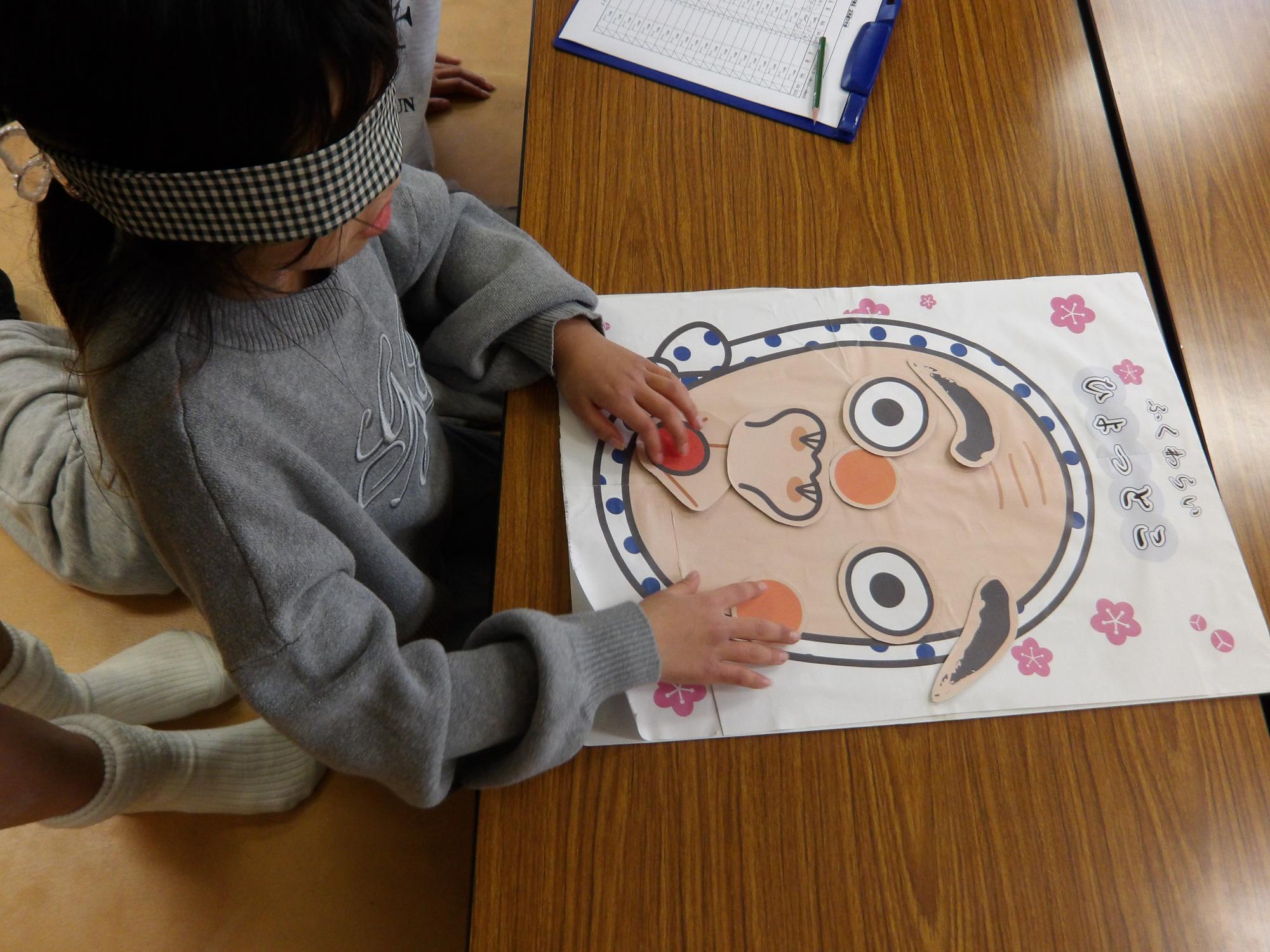 子どもが福笑いをしている写真