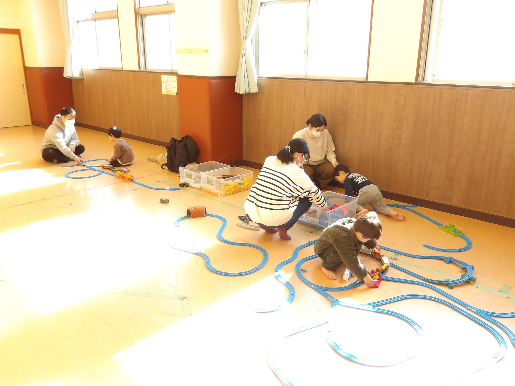 幼児親子がプラレールで遊んでいる様子