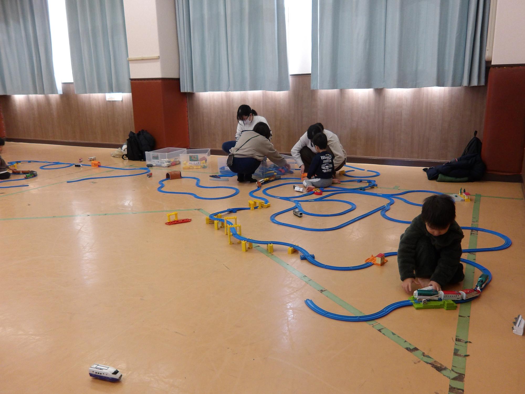 幼児親子がプラレールで遊んでいる様子