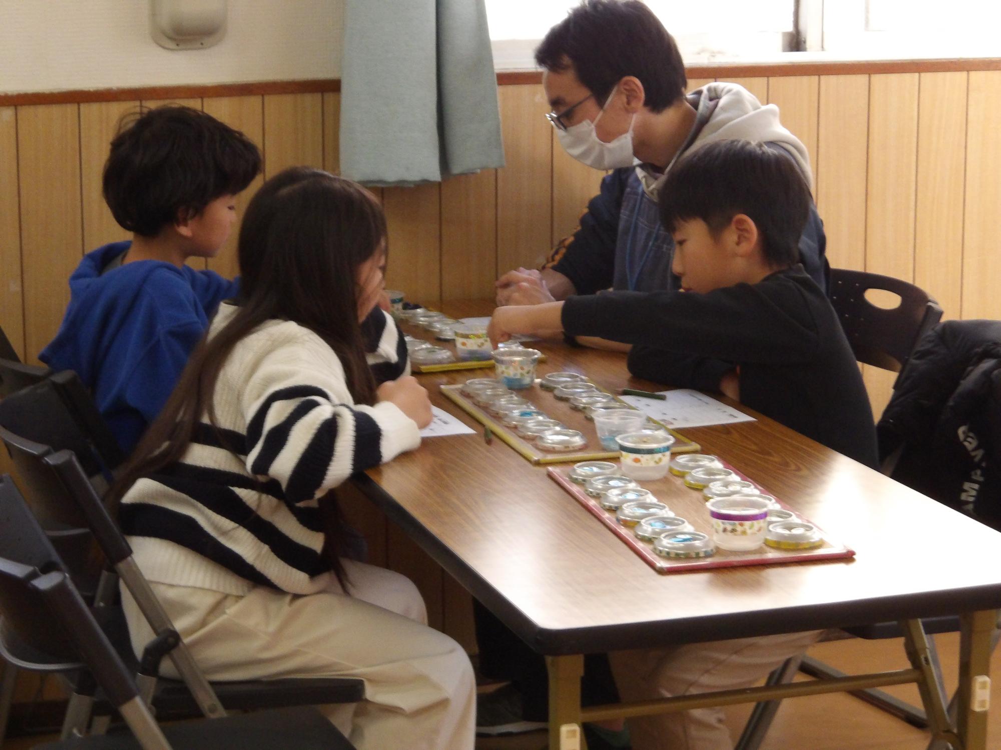 子どもたちがマンカラ対戦をしている写真