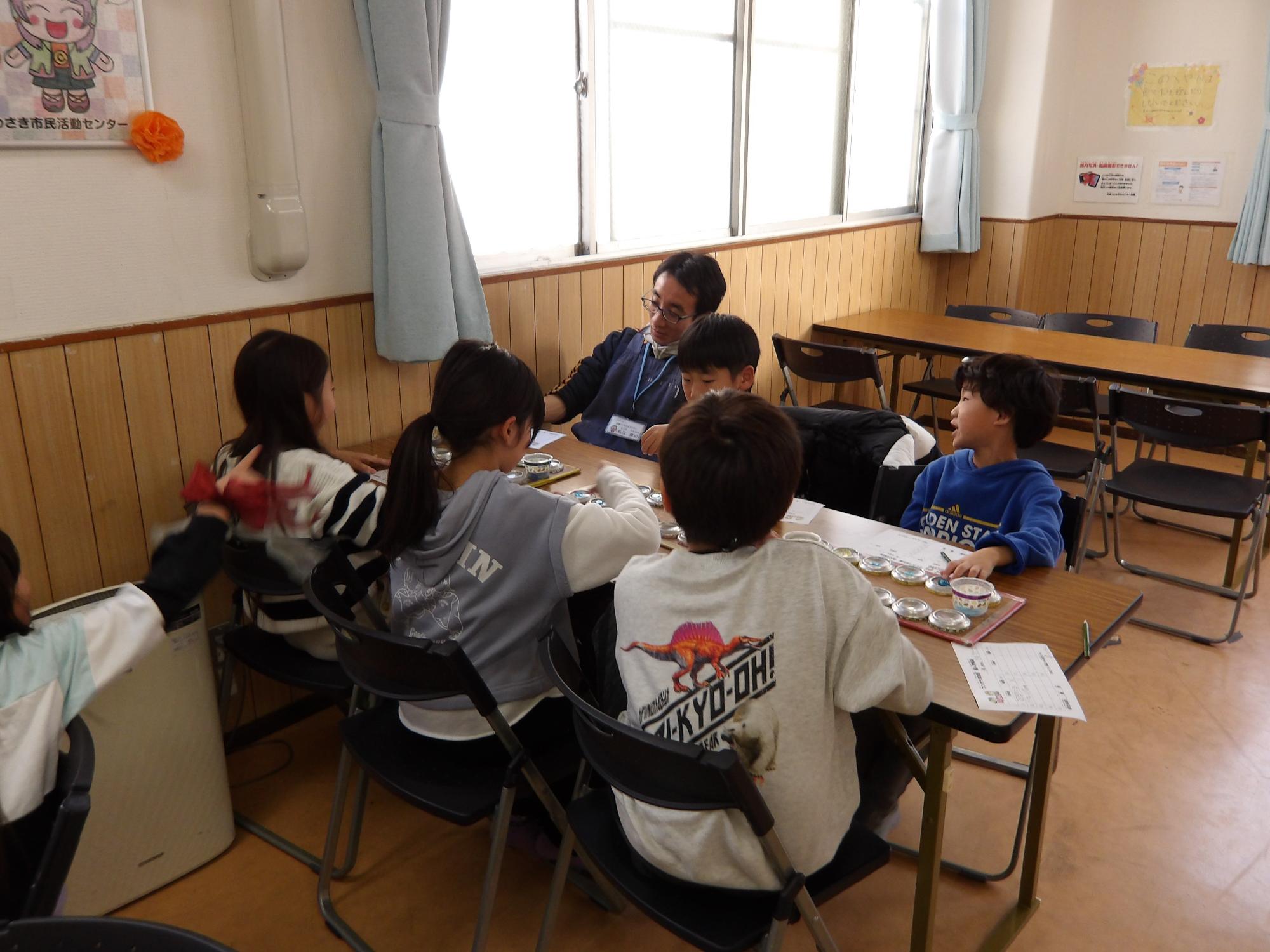 子どもたちがマンカラ対戦をしている写真
