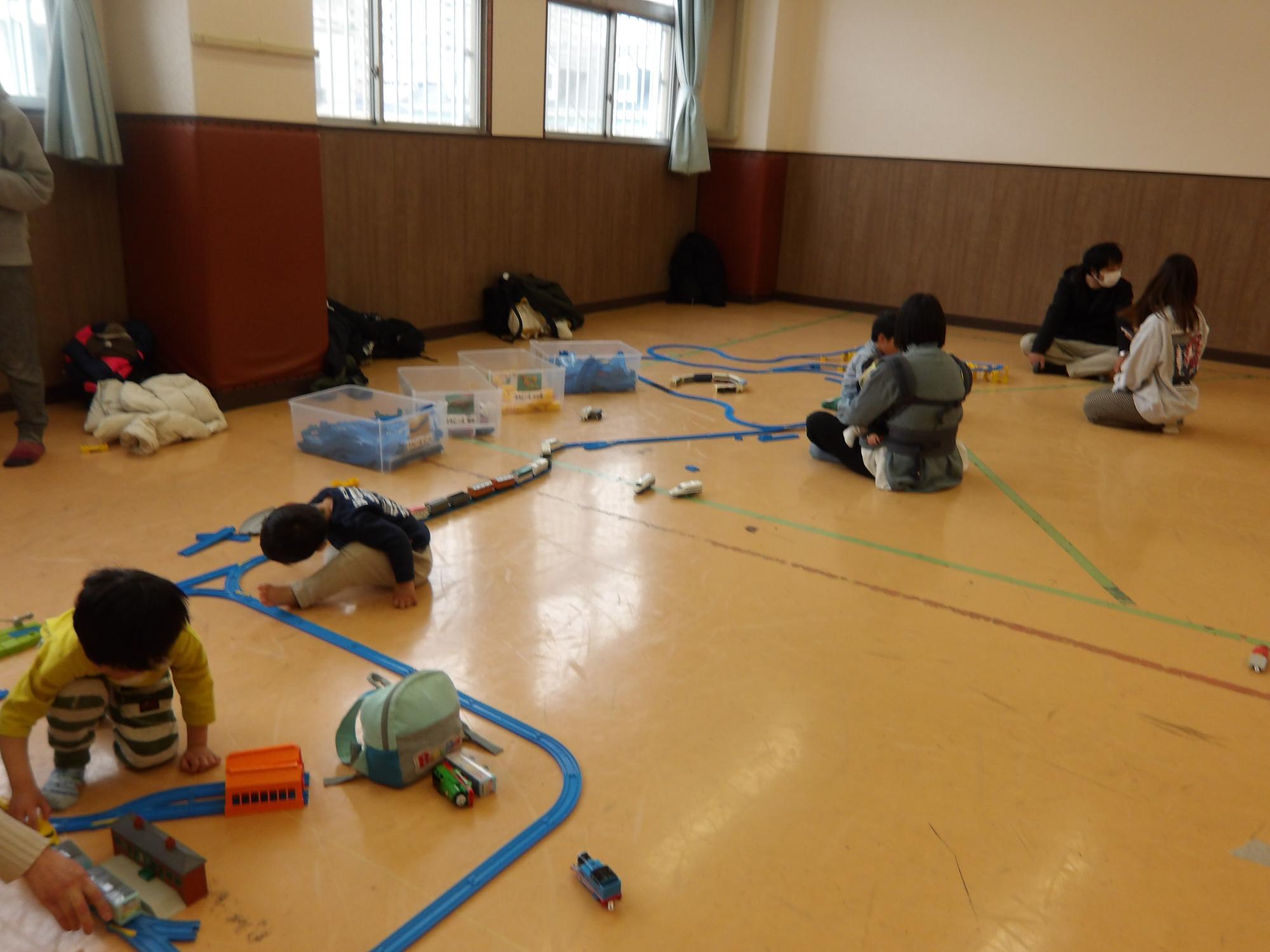乳幼児親子がプラレールをしている写真