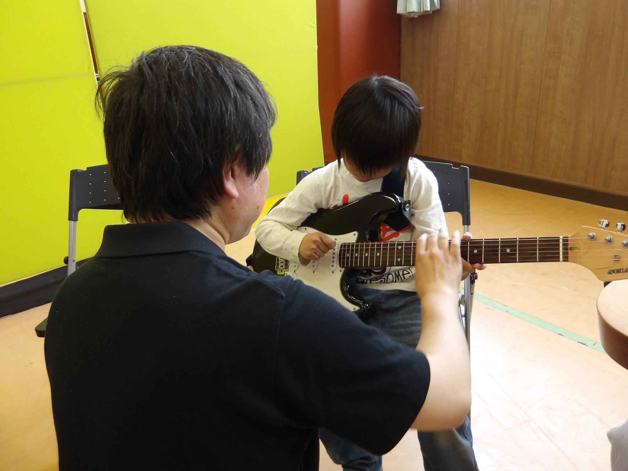 ギターを体験している子どもの写真