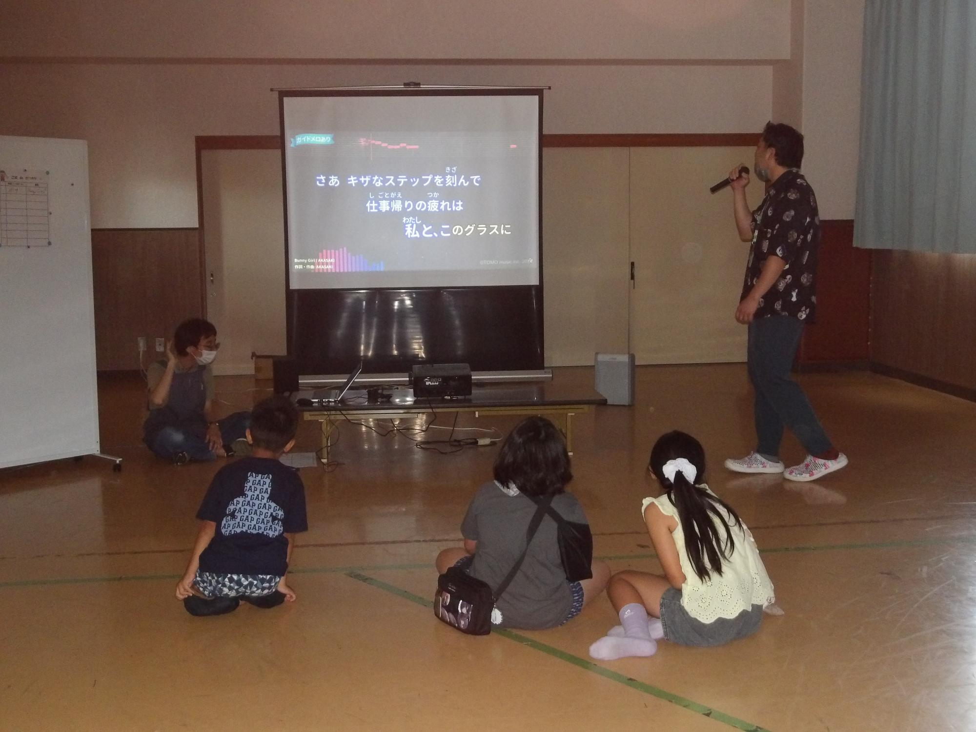 カラオケ行事で歌を歌っている様子の写真