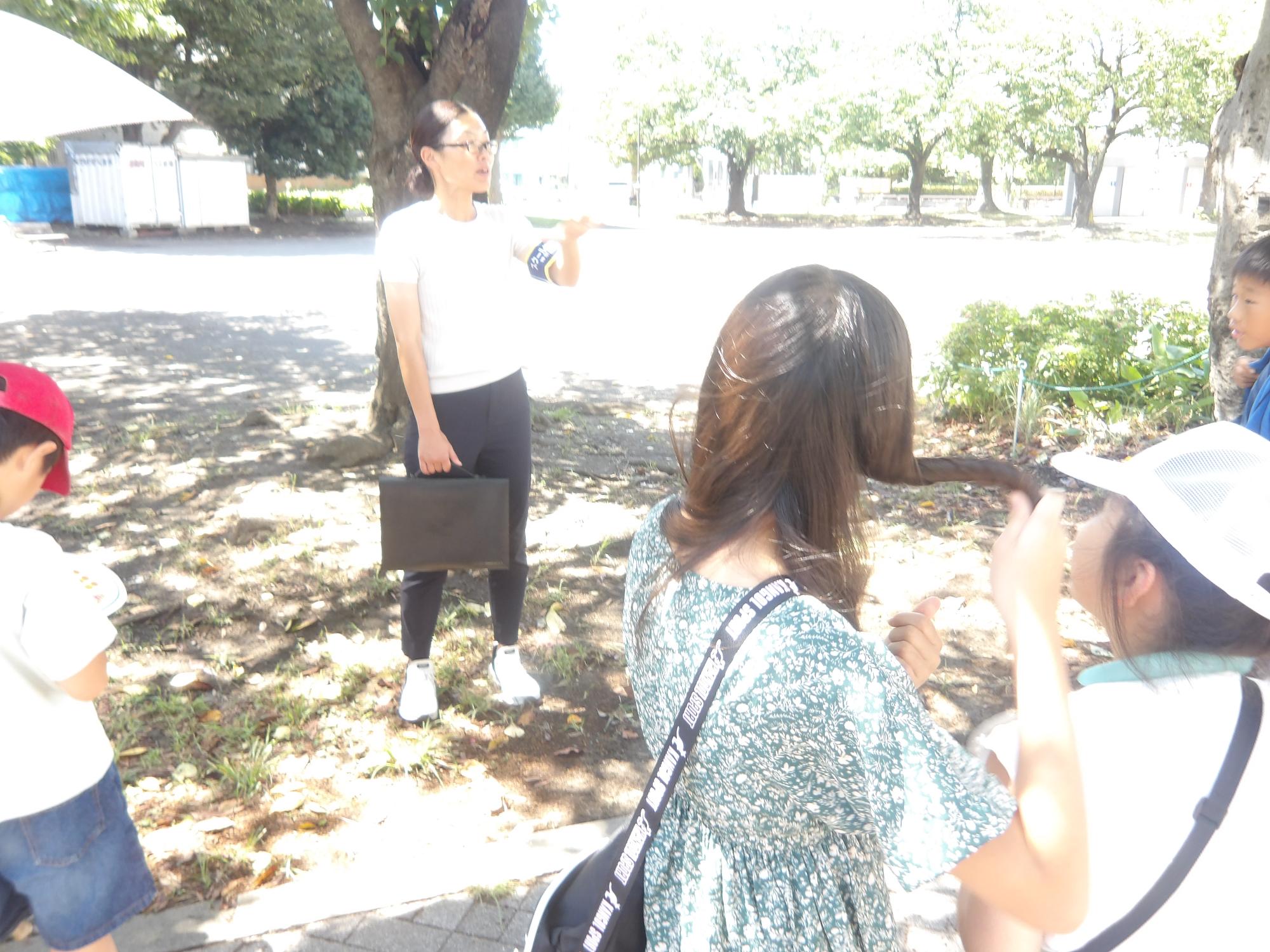 警察職員から近隣の公園などで安全な場所の説明を聞いている様子の写真