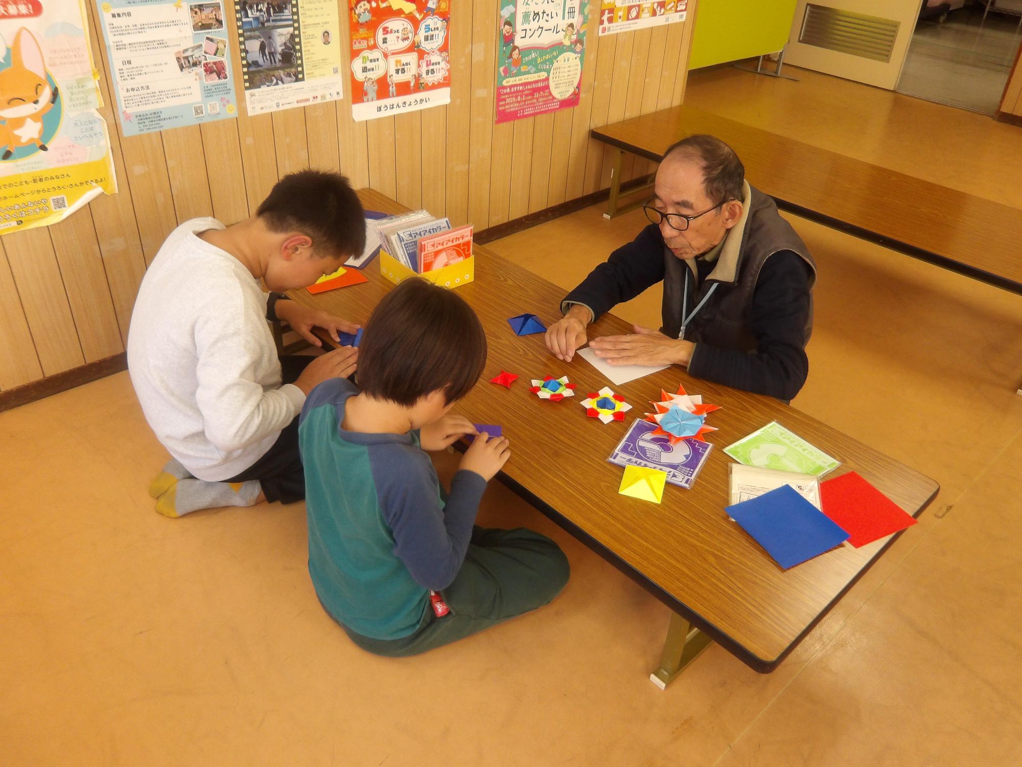 おりがみでコマを作っている様子の写真