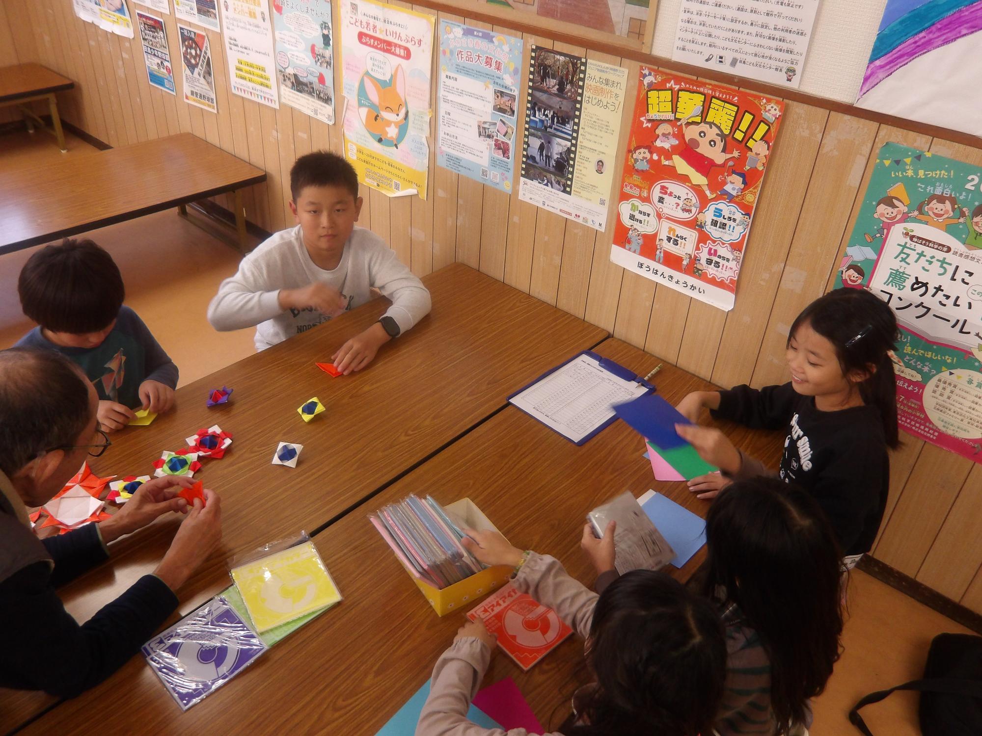 おりがみでコマを作っている様子の写真