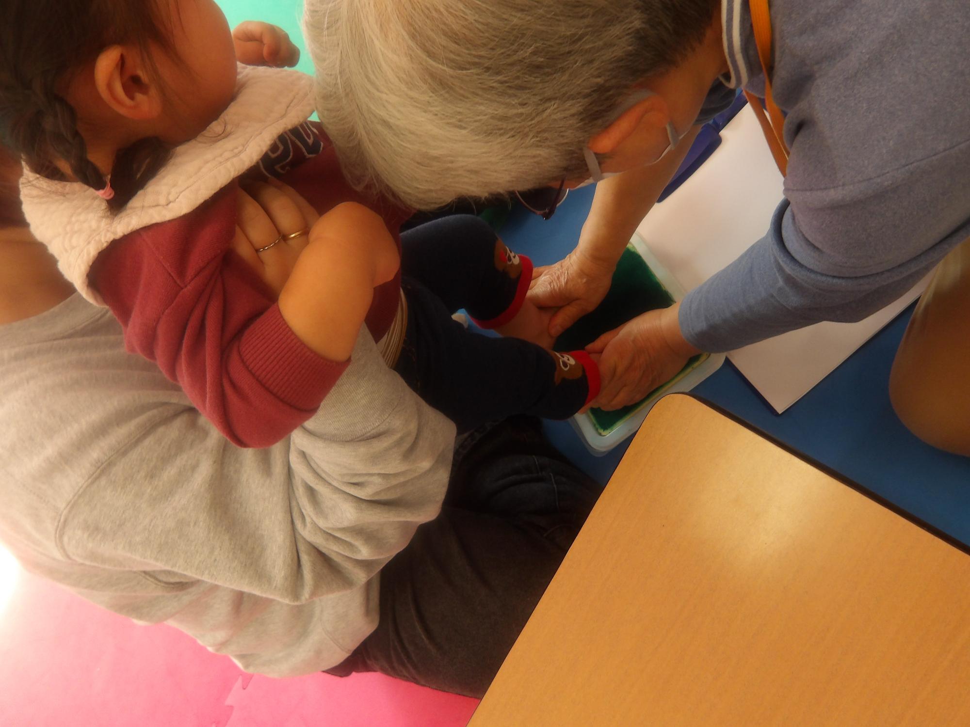 足形スタンプを押している様子の足形