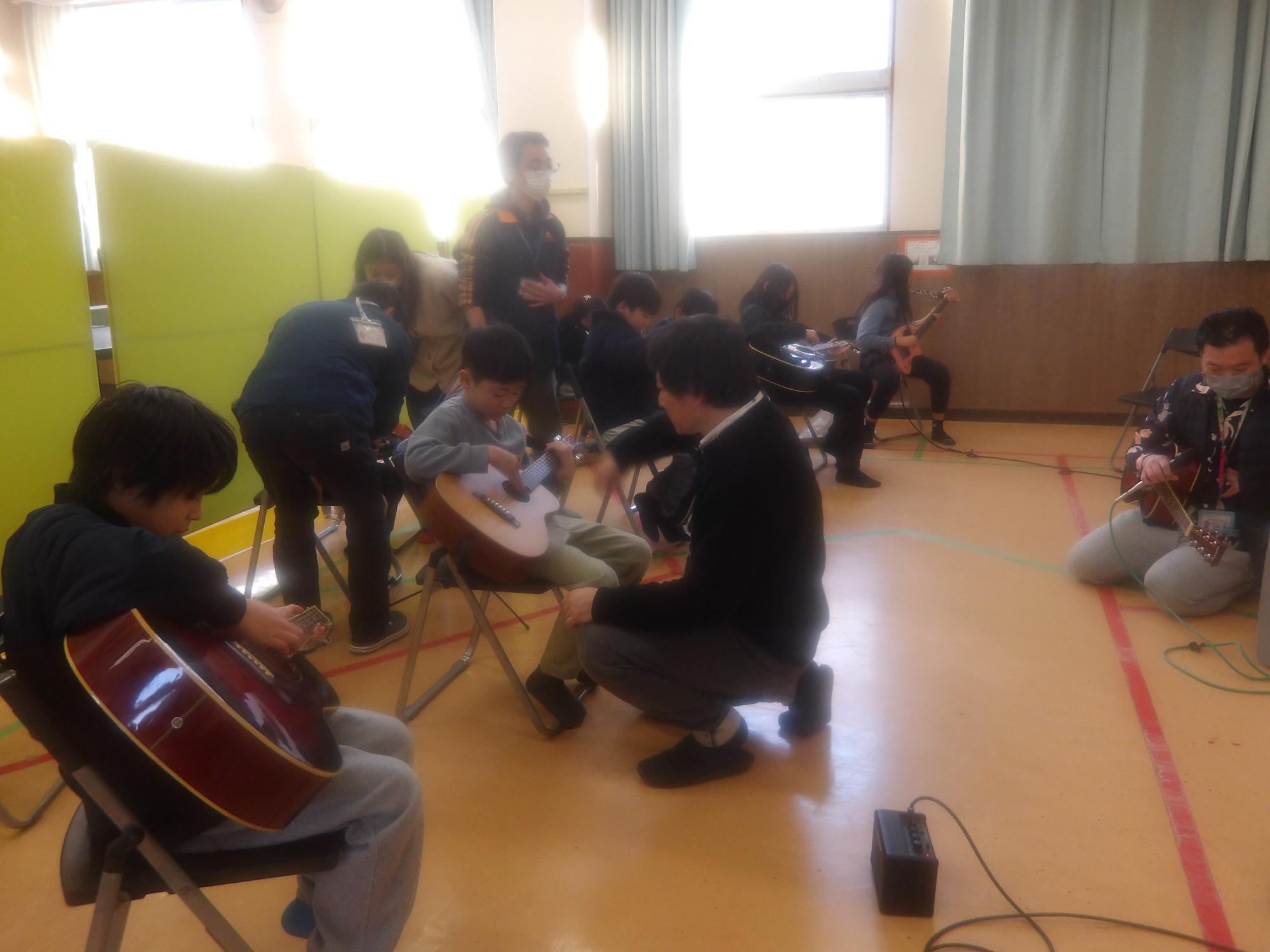ギターを弾いている子どもたちの写真