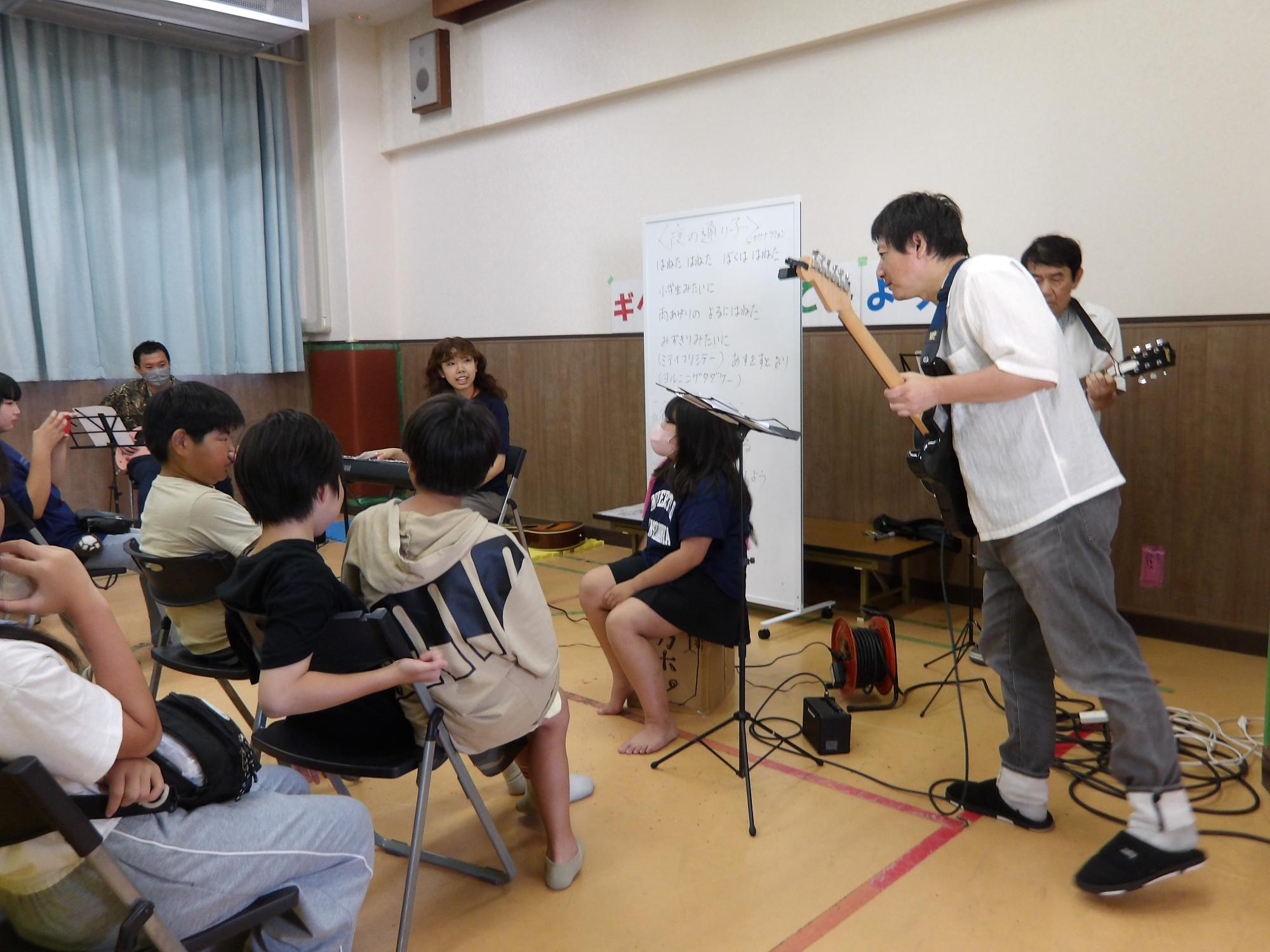 職員がギターを弾いている姿の写真