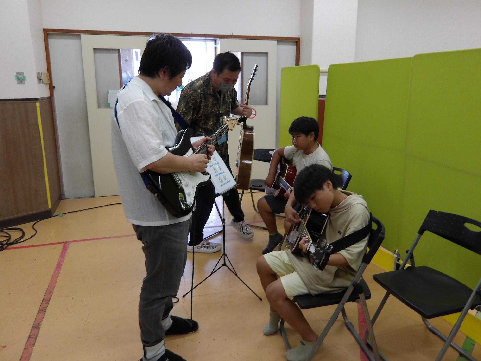 ギターを教えている姿の写真