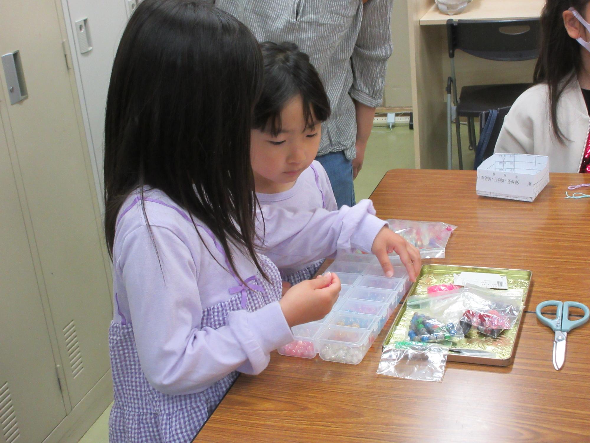 参加の子どもたちがビーズを選んでいる様子の写真
